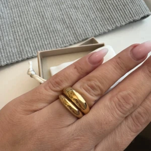 Mockberg ringar  - Mockberg bold gold ring Mockberg classic ring gold  Båda är storlek 54 = storlek 17   Bada, duscha och dansa i den utan oro för att den ska tappa färg. Tillverkad av massivt rostfritt stål med en 18K guld PVD-plätering, vilket gör den vattentålig. 