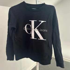 Svart sweatshirt från Calvin Klein - Snygg svart sweatshirt från Calvin Klein med stort CK-logotyptryck på framsidan. Tröjan har långa ärmar och en rund halsringning. Perfekt för en avslappnad stil. Använd en gång🤍🤍