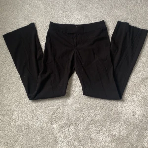 Svarta byxor från Nelly - Säljer ett par svarta kostym byxor från Nelly i storlek 34. Byxorna är Low waist bootcut. Perfekta för både vardag och fest! Bra skick lite noppriga då de är väl använda. De är också upp sprättade längst ner för att de ska bli längre💗