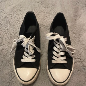 Svarta sneakers - Svarta låga sneakers i storlek 36!   Inga defekter, de ser lite använda ut. Har inte tvättat dem men bortsätt från snörena och undersidan så ser den ren ut. Går ju att tvätta såklart! På bild 4 kan man se små, små repor på dessa "ringar" men de knappt något man ser :)   Kontakta mig om ni har några frågor!
