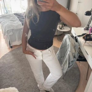 Vita low straight jeans - Snygga vita low straight jeans med låg midja och rak passform. Perfekta för en stilren look. Midjemått är 29 och längd 32. Klassisk design med fem fickor och knappgylf.Mittbenslämgden 76cm Benlängden midjan ner 106cm Midjemåttet 38cm