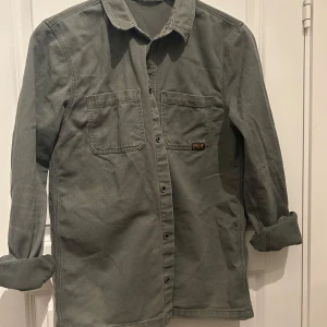 Olivgrön overshirt - Snygg overshirt i olivgrön från HM. Passar perfekt till våren! Skriv för mer bilder.