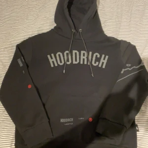 Svart hoodie från Hoodrich - Säljer en svart hoodie från Hoodrich med tryck både fram och bak. Den är helt ny. Den kostar egentligen 2000 kr. Men mitt pris är bara 800 kr.