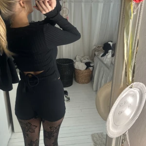 topp m rosett - ribbad tajt tunn topp. Knyte i ryggen med hyfsat breda band. Halvt croppad, går till naveln (på mig).