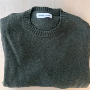 Grön tröja från Samsøe Samsøe - Säljer en grön tröja från Samsøe Samsøe i storlek L, sitter dock som en M. En bekväm och skön regular fit crewneck, gjord i ett mjukt material -  en väldigt härlig ullblandning. Köpte i vintras men känner att någonting annat ska få ta plats o garderoben. Vid frågor så är det bara höra av sig!