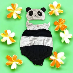 Söt panda-mössa för barn och body - En gullig mössa för barn med panda-design. Mössan är vit med svarta detaljer som formar pandaansiktet och öronen. Perfekt för att ge en lekfull touch till barnets outfit. 6-12 månader 