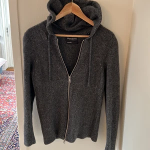 Grå hoodie från Marc O'Polo - Säljer en stilren grå hoodie från Marc O'Polo i italienskt garn. Tröjan har en dragkedja framtill och en bekväm huva med snörning. Står att den är M men den sitter som S. Bara att skriva vid frågor eller funderingar. Pris kan diskuteras 