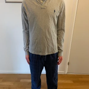 Ralph lauren långärmad piké  - En grå långärmad piké från Ralph Lauren. Den är i storlek M men passar S. Den är knappt använd och har inga tecken på skador. Kom privat om ni har frågor, pris går att diskutera vi snabb affär!