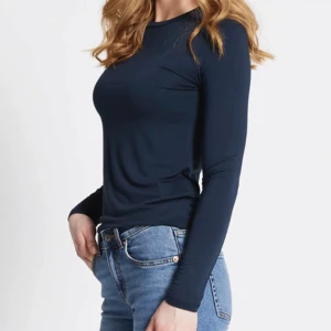 Mörkblå långärmad topp  - Toppen är i mjuk och stretchig viskosblandning med tight passform och rund halsringning. Perfekt att styla med jeans eller kjol för en clean look.