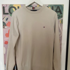 Tommy Hilfiger tröja - Snygg beige tröja från Tommy Hilfiger i storlek S. Klassisk rund halsringning och diskret logga på bröstet. Tillverkad i mjuk bomullsmix med polyester för extra komfort. , kom privat för fler frågor och funderingar:).