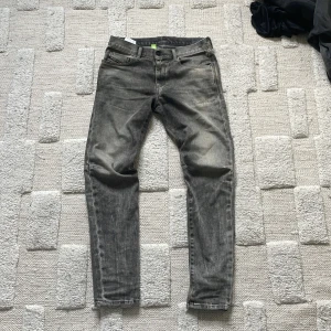 Diesel D-Strukt grå jeans W30 L32 - Säljer ett par grå Diesel D-Strukt jeans med snyggt tvättad look. Modellen har klassisk femficksdesign, smal passform och stretchigt material för extra komfort. Perfekta för dig som gillar en modern och avslappnad stil.