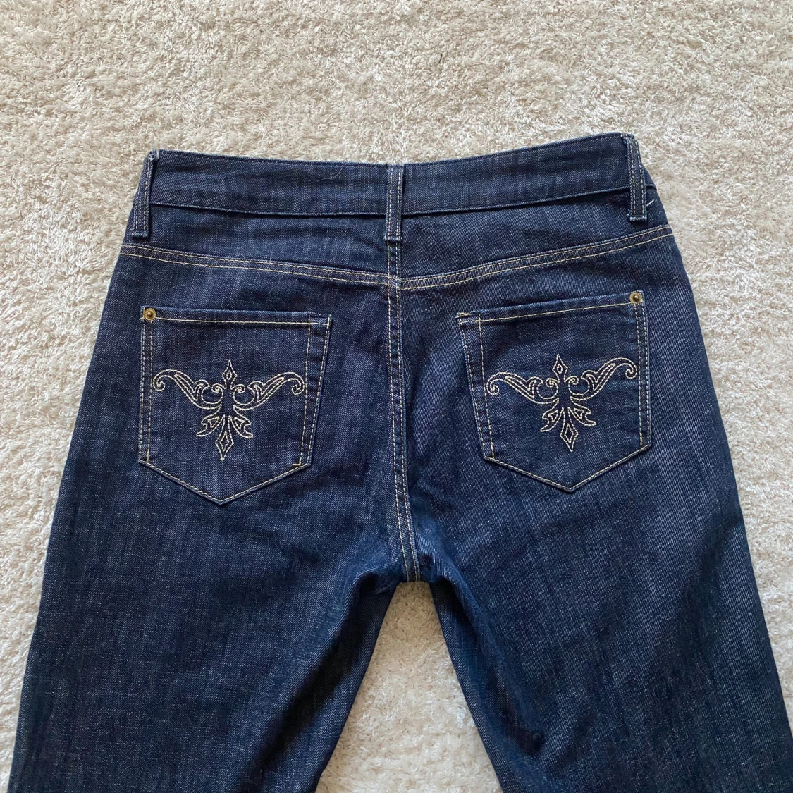 Mörkblå jeans med broderade bakfickor