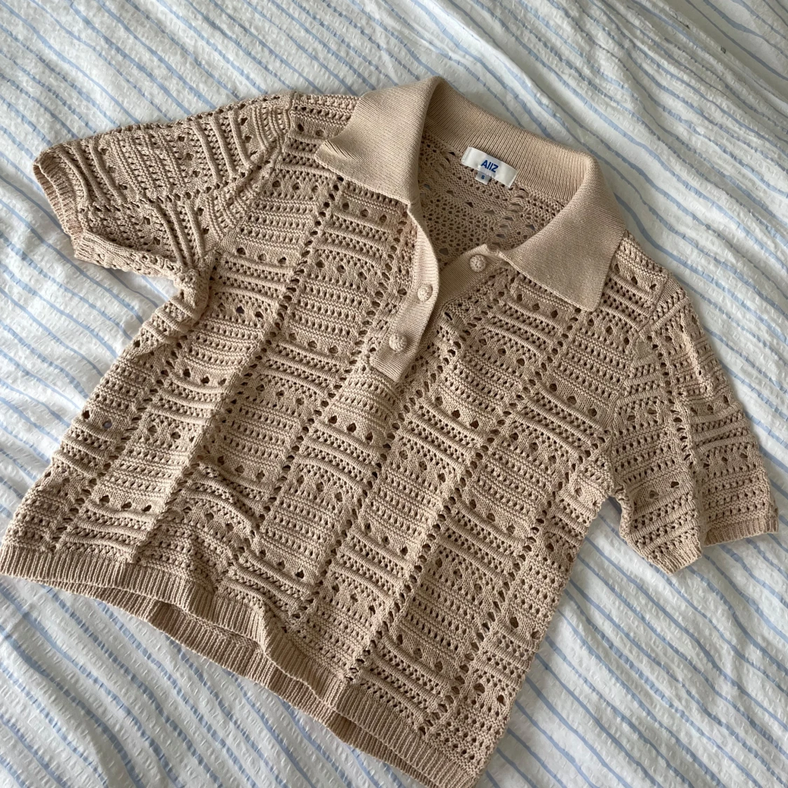 Beige stickad pikétröja från AIIZ