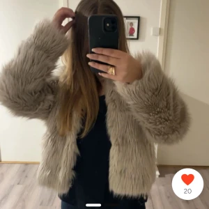 Beige pälsjacka med lång lugg - Säljer en supermjuk och fluffig beige pälsjacka med lång lugg. Jackan är croppad och har långa ärmar, perfekt för att ge en cool och trendig vibe till din outfit. Passar perfekt till både jeans och klänning. Ingen synlig dragkedja eller knappar.