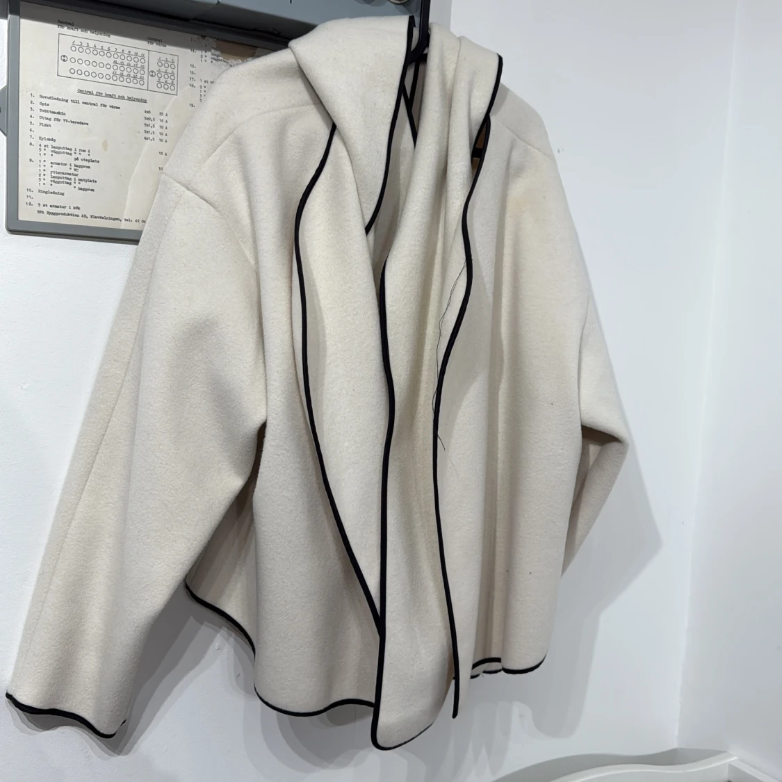 Vit omlottjacka med svarta kanter