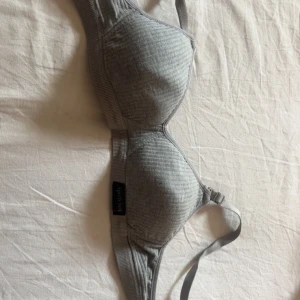 Grå ribbad linnetopp från Sportsbelt - Snygg grå ribbad linnetopp från Sportsbelt med justerbara axelband. Toppen har en sportig look och är tillverkad i mjukt material som sitter skönt mot kroppen. Perfekt för dig som gillar enkel och stilren design.