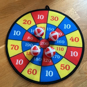 Darttavla  - En darttavla med färgglada poängfält och fyra bollar med kardborreband. Perfekt för roliga tävlingar och aktiviteter med vänner eller familj.