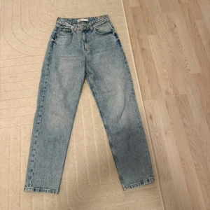 Ljusblå raka jeans från zara - Säljer ett par klassiska ljusblå jeans från Zara med rak passform. Jeansen har hög midja och en snygg vintage tvätt. Perfekta till sneakers eller boots och passar till många olika stilar.