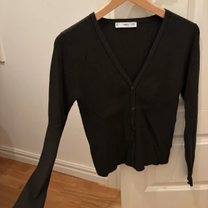 Mörkgrön ribbad kofta från MNG - Ny utan prislapp! Mörkgrön ribbad kofta från Mango i storlek S. Koftan har v-ringning, långa ärmar och knäppning framtill.