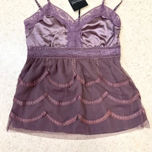 Lila spetsig linnetopp från Cinderella - Coquette top with lace details from the brand rant and rave tag says XS but it fits XXS 