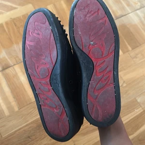 Svarta Louboutin sneakers med nitar - Loubs skor använda många gånger, smutsiga som ni ser med några skador för mer info skriv. Har haft de i typ ett år. Det går att ha på sig efter rengöring.