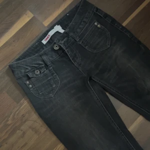 Svarta bootcut jeans från ONLY - Assnygga lågmidjade jeans från Only, de är mer åt det bootcut hållet! De har sytts om på rumpan som man kan se. Kanske går att sprätta upp o sy det lite finare om man vill det! Sedan också lite slitna längst ner vid benen men annars riktigt snygga 💞 Midjemått: 34 cm Innerbenslängd: 75 cm