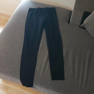 Svarta leggings med stretch - Svarta leggings med smal passform och elastisk midja. Perfekta för chill dagar eller när du vill ha något bekvämt och enkelt. Materialet är mjukt och stretchigt, vilket gör dem sköna att bära hela dagen.