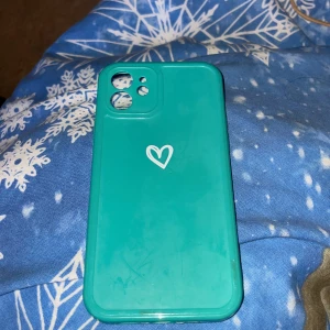 Turkost/grönt silkonskal för mobilen (IPhone 12) - Turkost/grönt silkonskal för mobilen, passar för iPhone 12. Har tecken på slitage (se bilder) dock endast använt några enstaka gånger!  Ordinarie priset ligger på 111,68kr!