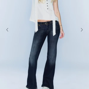 Mörkblå bootcut jeans med slitningar - Snygga mörkblå jeans med bootcut-modell och coola slitningar framtill. Jeansen har låg midja. Storlek 25/30