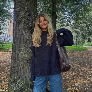 Mörkblå chunky stickad tröja - Chunky mörkblå stickad tröja med grovt flätmönster och breda muddar. Oversized fit och långärmad, perfekt för lager-på-lager. Storleken är S/M och den är nopprig.