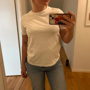 Vit basic t-shirt i bomull - vit t-shirt med rund hals och korta ärmar. 