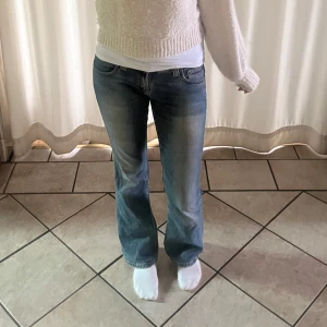 Nudie jeans bootcut lågmidjat - Modellen är vintage så ganska svåra att få tag i. De är ett par ljusblå lågmidjade Nudie jeans med bootcut passform. Jeansen har Nudie-logga på bakfickan. Materialet är mjukt jeans i bomull med lite stretch för skönare fit.