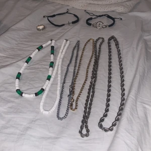 Dunder smycken - Säljer ett paket med flera halsband och armband. Inkluderar pärlhalsband i vitt och grönt, kedjehalsband i silver och guldton, samt två svarta armband – ett med kors och ett med silverfärgad detalj.  Fråga bara om du undrar pris för vissa smycken