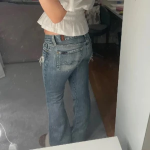 Lågmidjade jeans -  Säljer ett par blå bootcut jeans med slitna detaljer.  (Lånade bilder) 38cm midja, 83 innerbenslängd💕Köpte dessa av en annan tjej här på Plick men det passade tyvärr inte💕