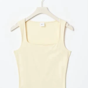 Ljusgul linnetopp med fyrkantig ringning - Supersnygg ljusgul linnetopp från Gina  med breda axelband och fyrkantig ringning. Perfekt att styla med jeans eller kjol för en fräsch look. Mjuk och skön bomullskänsla, passar perfekt till varmare dagar.