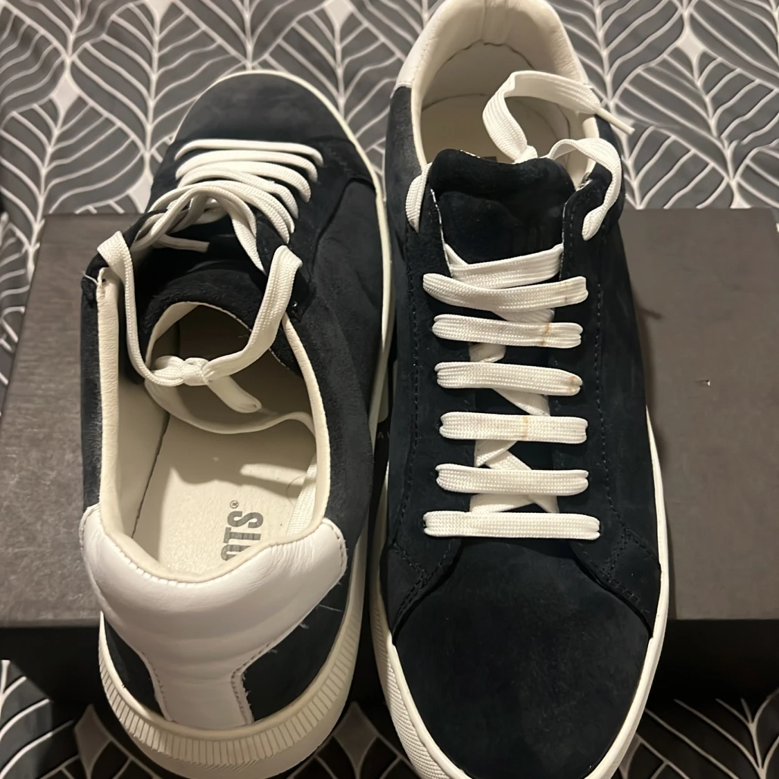 Svarta mockasneakers med vita detaljer