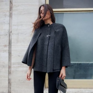 Mörkgrå poncho-kappa från Zara - Säljer en super fin grå poncho-kappa från Zara. Aldrig använd och prislappen sitter kvar. Storlek L och köpt för 399kr säljer för 370.
