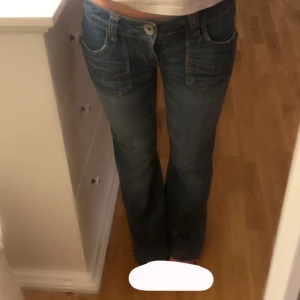 Low rise bootcut jeans från Only - Snygga blå low rise jeans från Only med bootcut-ben. Jeansen har fickor både fram och bak. Storlek xxs. De är sydda i midjan med inget man lägger märket till. Skriv för mått eller andra frågor!💕