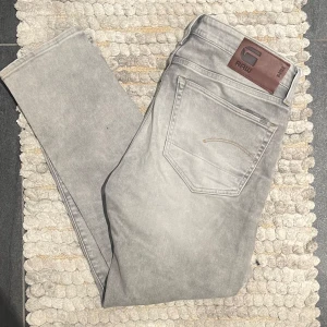 Grå jeans från G-Star RAW - Snygga grå jeans från G-Star RAW med en klassisk femficksdesign. De har en rak passform och är tillverkade i ett slitstarkt denimtyg. Perfekta för en avslappnad stil.