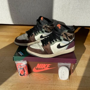 Nike Air Jordans  - säljer nu mina snygga Nike Air Jordans med en mix av bruna, vita och svarta nyanser. Skorna har en hög design med snörning och en klassisk Nike-logga på sidan. Har använt dom 2 år och är fortfarande i väldigt bra skick. Har ett skrap märkte på sidan av hälen men annars väldigt fina skor, box och extra snören följer med skorna|(storlek40,5) nypris 1500kr och går nog inte att köpa nya längre|hör av dig vid minsta fundering💭|pris går att diskuteras