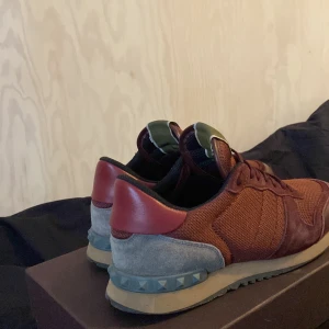 Vinröda sneakers från Valentino  - Snygga vinröda sneakers från Valentino Garavani med en stilren design. Skorna har en kombination av mocka och syntetmaterial med klassisk snörning. Perfekta för en trendig look. 7/10 i skick skriv om du är intresserad kan också byta mot andra skor