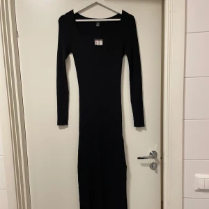 Svart ribbad långklänning - Lăng Ribbstickad klänning med slits pả vänster sida. Prislappen kvar (retur policy gick ut). Skön och stretchig. Nypris: 299kr