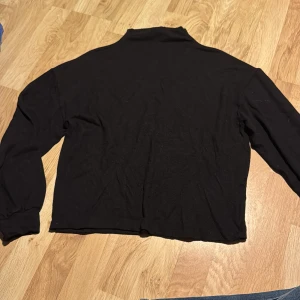 Svart tröja från Gina Tricot - Säljer en svart tröja från Gina Tricot i storlek S. Tröjan har långa ärmar och en enkel design som passar perfekt till vardags. Den är tillverkad i ett mjukt material som känns skönt mot huden.