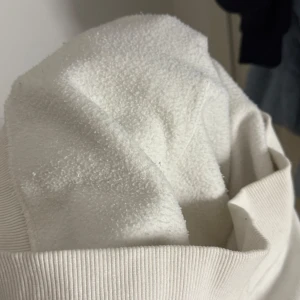 Vit hoodie från Superdry - Säljer en vit hoodie från Superdry med färgglad logga på framsidan. Den har en stor ficka framtill och justerbar huva med snören. Perfekt för en avslappnad stil. 🧡 Väldigt ny i skick och är sann till storlek (inte oversized)