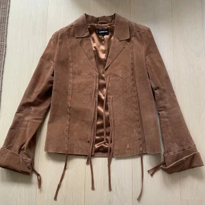 Brun mockajacka från ONLY - Snygg brun mockajacka från ONLY! Jackan har långa ärmar och en stilren design som passar perfekt för höst och vår🤩💕