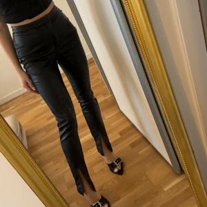 Svarta byxor med slits - Snygga svarta byxor i syntetmaterial med hög midja och tight passform. Na-kd 