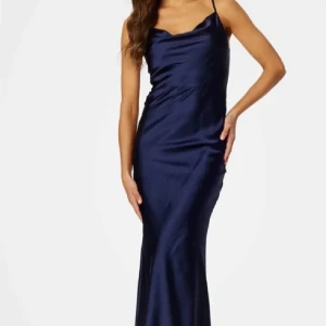 Marinblå långklänning i satin - Elegant marinblå balklänning i satin med smala axelband. I strl 42 vilket motsvarar strl L/XL Perfekt för en stilfull kväll med sin slanka passform och glänsande material. Den är i nyskick och prislappen är på. Helt slutsåld. 
