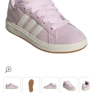 Rosa sneakers från Adidas - Snygga rosa sneakers från Adidas med klassiska vita ränder på sidan. Skorna har en bekväm passform och är perfekta för vardagsbruk. De är tillverkade i mocka och har en vit sula med bra grepp.