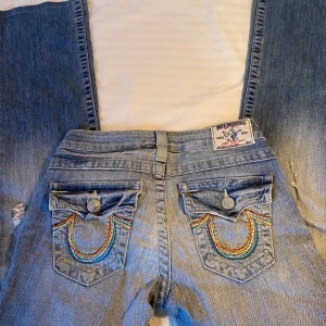 True Religion jeans - Äkta low waist trueys, väldigt unika broderade detaljer på bakfickorna. De har en klassisk femficksdesign och en dragkedja framtill👊köpta på en second hand butik i USA