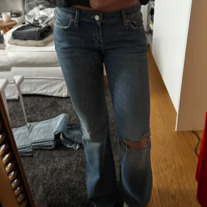 Blå bootcut jeans - Lågmidjade bootcut jeans från Weekday, skulle säga att dem är storlek 36/S. Helt nya, med snyggt hål på knät